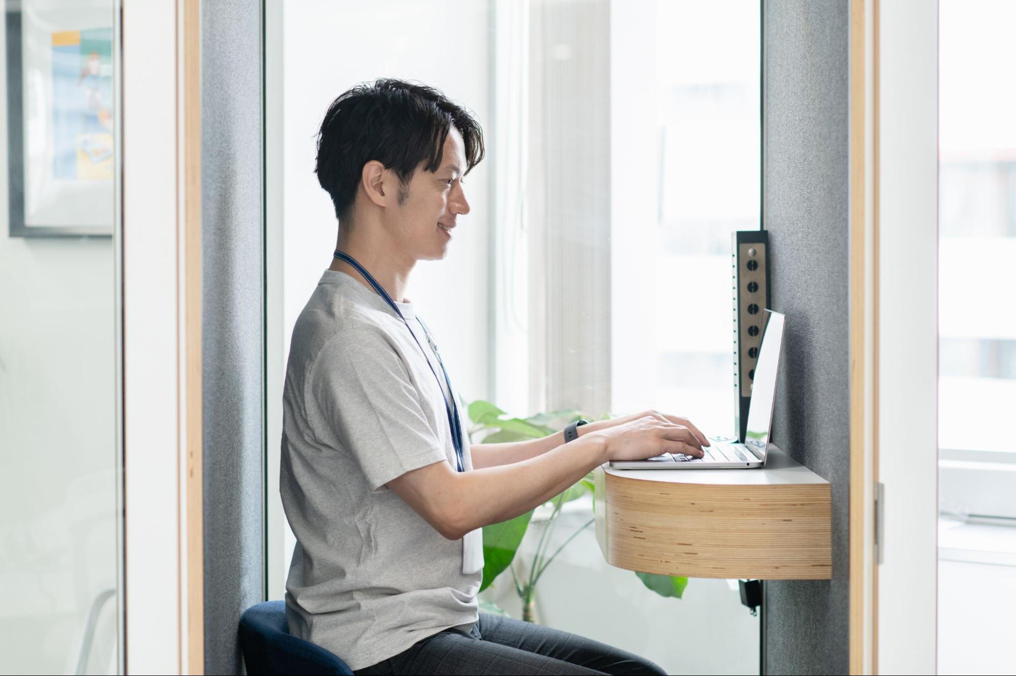 コワーキングスペースのフリー席や固定席が並ぶ明るいワークスペースの写真