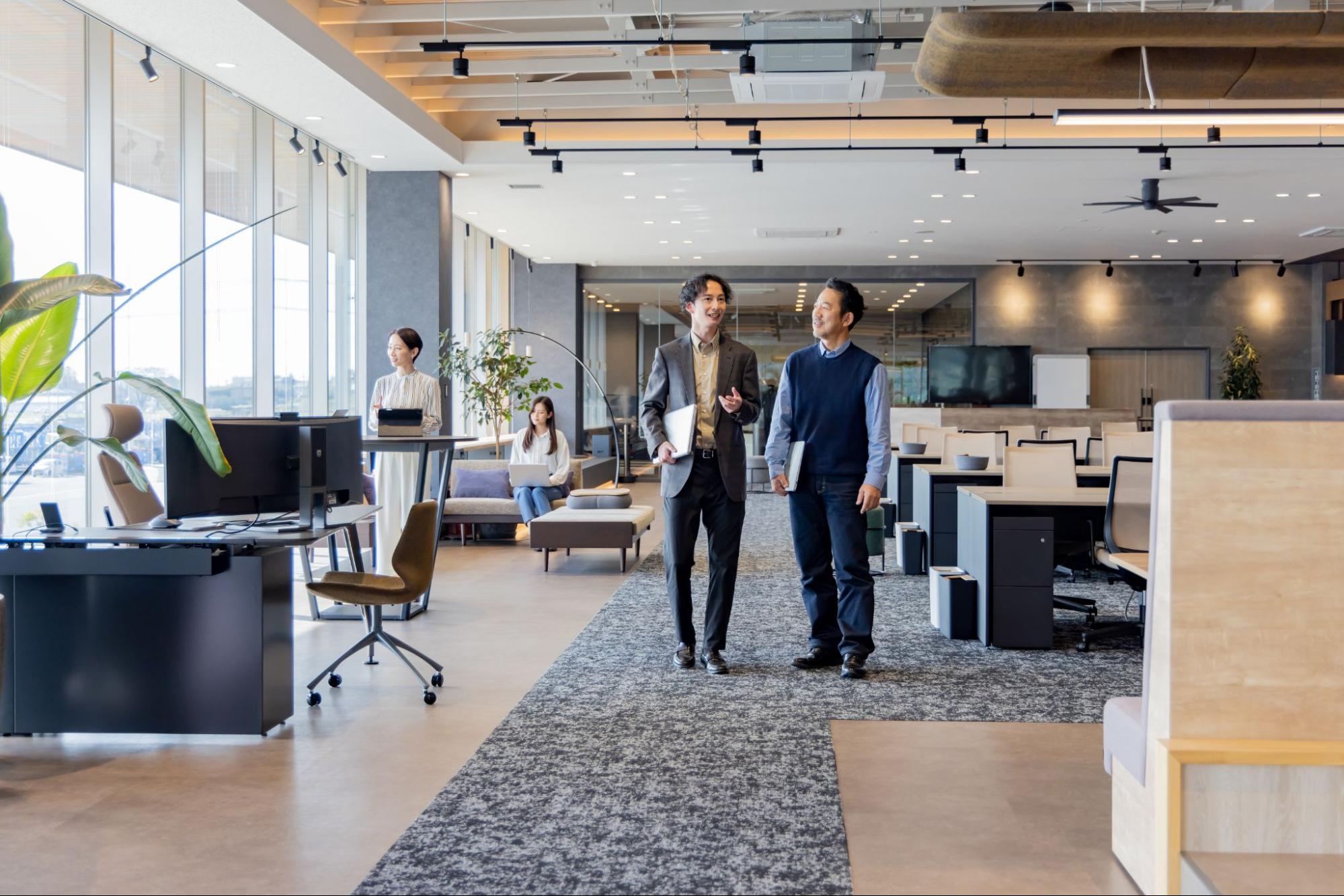 コワーキングスペースで会話をしながら仕事をする利用者の写真