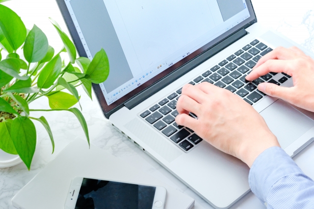 レンタルオフィス選びについてパソコンで調べる男性