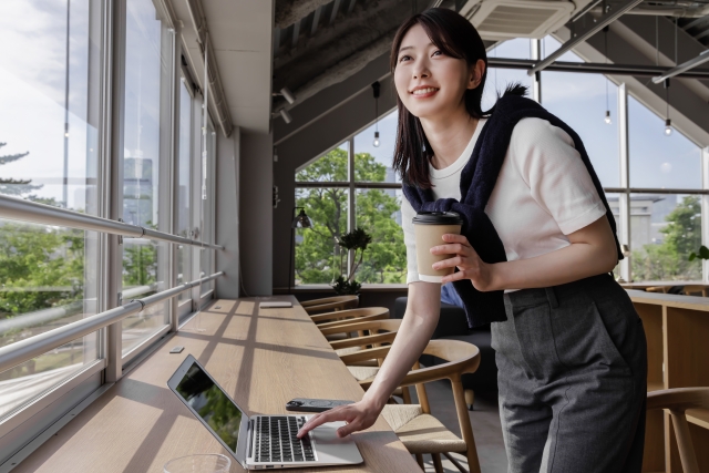 共有スペースのあるレンタルオフィスで作業する女性