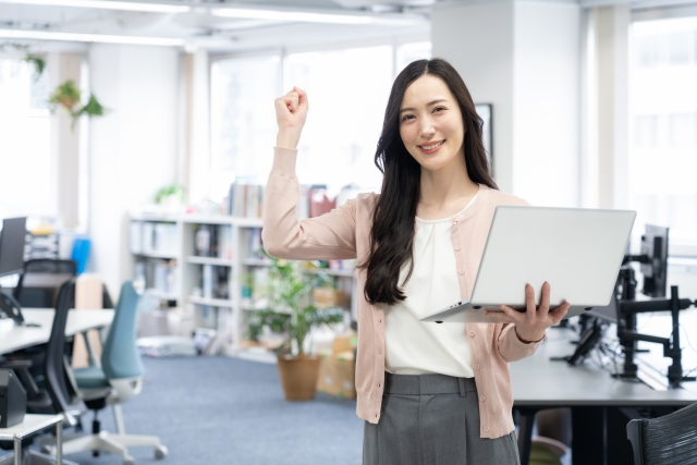 オフィス出社で対面コミュニケーションを取る笑顔の女性社員