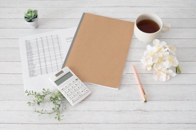 書類が並ぶデスクとオフィス空間のイメージ写真