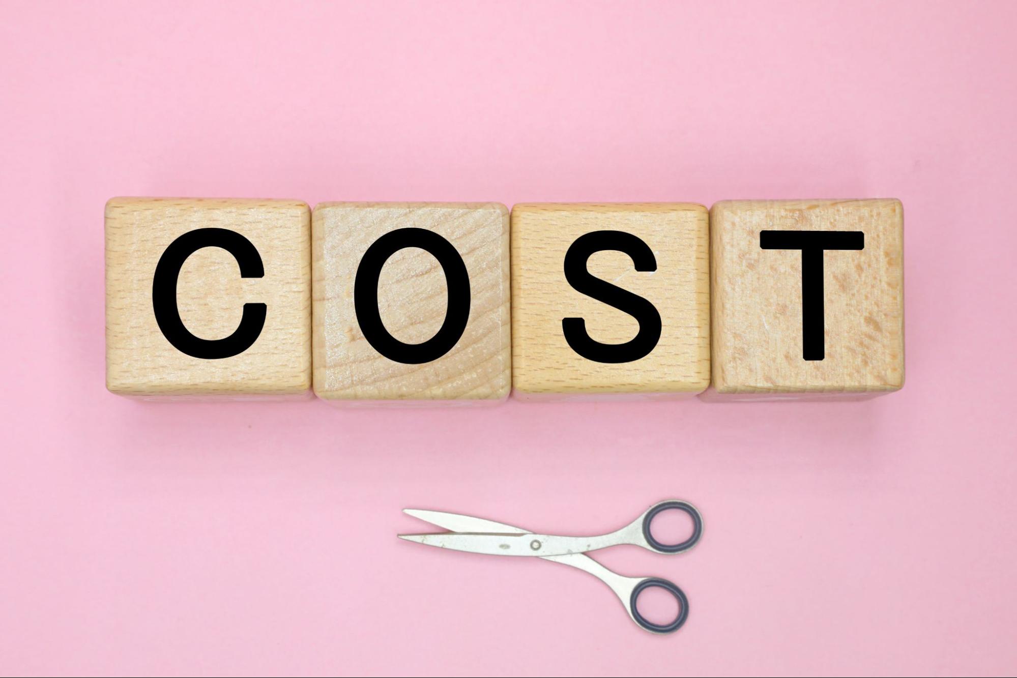 木のブロックに英語でCOSTと書かれている