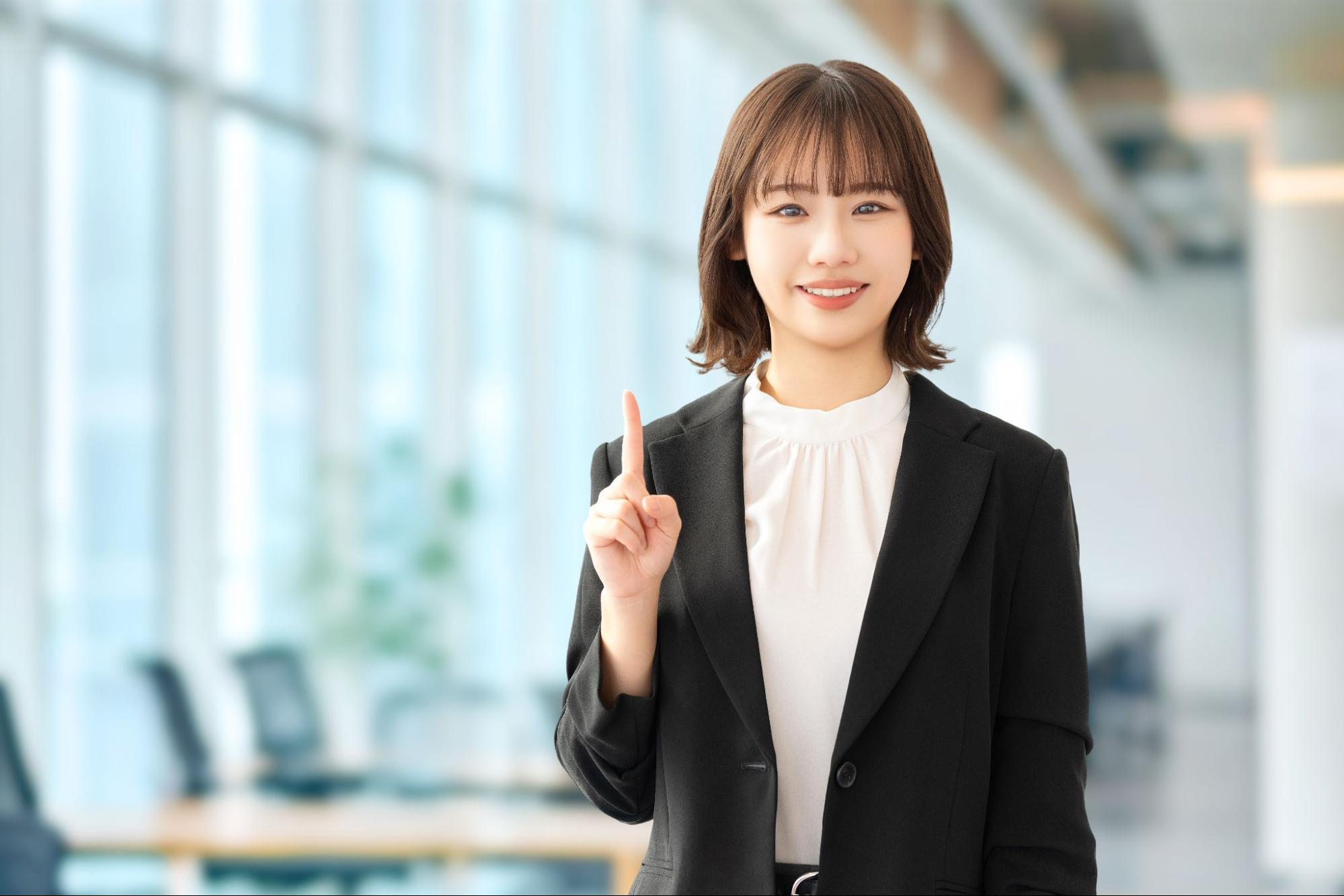 オフィスで笑顔でポイントを示す女性